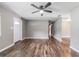 A view of the living room showcasing wood-look floors, light gray walls, and a ceiling fan at 2612 Lenna Ave, Seffner, FL 33584
