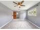 Spacious main bedroom with a ceiling fan, large windows, and wooden door to the bathroom at 2612 Lenna Ave, Seffner, FL 33584