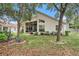 Exterior view of the home showcasing a spacious backyard and screened patio at 371 Quane Ave, Spring Hill, FL 34609