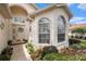 Inviting front entrance with arched windows, a decorative door, and colorful landscaping at 371 Quane Ave, Spring Hill, FL 34609