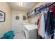 Functional laundry room with a washer, dryer, storage shelves, and a hanging rack at 371 Quane Ave, Spring Hill, FL 34609