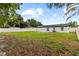The home has a backyard with a privacy fence, grassy lawn, and mature trees at 3909 W Oklahoma Ave, Tampa, FL 33616