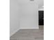 This empty bedroom features neutral paint, light hardwood floors, and a black door at 3909 W Oklahoma Ave, Tampa, FL 33616