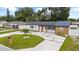 Beautiful single-story home with a modern driveway, complemented by lush landscaping at 3909 W Oklahoma Ave, Tampa, FL 33616