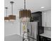 Close up of modern kitchen island with black and gold lighting fixtures and stainless steel appliances at 3909 W Oklahoma Ave, Tampa, FL 33616