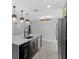 Well-lit kitchen featuring island with sink, black and gold hardware, and stainless-steel refrigerator at 3909 W Oklahoma Ave, Tampa, FL 33616