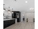Contemporary kitchen showcasing black and white cabinetry, quartz island, and elegant light fixtures at 3909 W Oklahoma Ave, Tampa, FL 33616