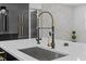 Close-up of kitchen sink, faucet, and kitchen island with quartz counter tops at 3909 W Oklahoma Ave, Tampa, FL 33616