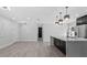 Open concept living area with modern kitchen and gray wood flooring at 3909 W Oklahoma Ave, Tampa, FL 33616