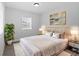 Bright main bedroom with gray vinyl floor, neutral walls and trim and a beautifully decorated queen sized bed at 3909 W Oklahoma Ave, Tampa, FL 33616