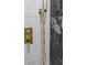 Close up of gold toned shower fixtures against a black marble tiled shower wall at 3909 W Oklahoma Ave, Tampa, FL 33616