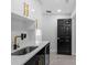 Wet bar with white and black cabinets, gold hardware, modern faucet and a wine refrigerator at 3909 W Oklahoma Ave, Tampa, FL 33616