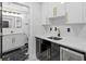 Wet bar with white cabinets, dark accent cabinets and gold hardware and a black marble tiled bathroom in the background at 3909 W Oklahoma Ave, Tampa, FL 33616