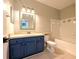 Bathroom with blue vanity and tub with tile surround at 4207 S Dale Mabry Hwy # 6212, Tampa, FL 33611