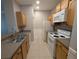 Bright kitchen featuring white appliances, wood cabinetry, and a double basin stainless steel sink at 4207 S Dale Mabry Hwy # 6212, Tampa, FL 33611