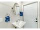 Bathroom sink and door, towel rack with blue towels, and oval mirror at 4362 Wesley Ln, North Port, FL 34287