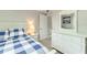 Cozy bedroom featuring a blue and white checkered comforter and a white dresser with a mirror at 4362 Wesley Ln, North Port, FL 34287
