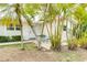 Home's front yard with palm trees, stone facade, and table with chairs at 4362 Wesley Ln, North Port, FL 34287