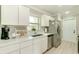 A modern kitchen features white cabinets, stainless steel appliances, and plenty of counter space at 4362 Wesley Ln, North Port, FL 34287