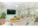 A well-lit living room features hardwood floors, comfortable seating, and a large wall-mounted TV at 4362 Wesley Ln, North Port, FL 34287