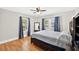 Bedroom with hardwood floors features a dark wooden bed frame with windows dressed with blue curtains at 4820 8Th S Ave, St Petersburg, FL 33711
