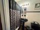 Bathroom with black fixtures, a patterned shower curtain and bright vanity lighting at 5901 N 34Th St, Tampa, FL 33610