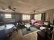 Living room featuring multiple seating areas, ceiling fans, and ample natural light at 5901 N 34Th St, Tampa, FL 33610
