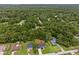 An aerial view of a home surrounded by lush greenery in a serene, wooded neighborhood at 6103 Fairway Dr, Ridge Manor, FL 33523