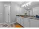 Bathroom featuring double vanity, granite countertops, shower, and wood-look floors at 6103 Fairway Dr, Ridge Manor, FL 33523