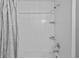 White tiled shower/tub combination with matching curtain and wall mounted shelves at 6103 Fairway Dr, Ridge Manor, FL 33523