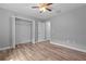 Neutral bedroom boasts wood-look floors, a ceiling fan and closet with wire shelving at 6103 Fairway Dr, Ridge Manor, FL 33523