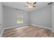 Neutral bedroom with a ceiling fan, wood-look floors, a window and white trim at 6103 Fairway Dr, Ridge Manor, FL 33523