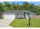 Beautiful single-story home with gray siding, well-manicured lawn, and a two-car garage at 6103 Fairway Dr, Ridge Manor, FL 33523