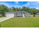 Charming single-story home featuring a gray exterior, well-manicured lawn, and attached two-car garage at 6103 Fairway Dr, Ridge Manor, FL 33523
