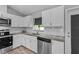 Well-lit kitchen featuring stainless steel appliances, granite countertops, and white cabinets at 6103 Fairway Dr, Ridge Manor, FL 33523
