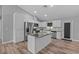 Modern kitchen featuring stainless steel appliances, a center island, and stylish white cabinetry at 6103 Fairway Dr, Ridge Manor, FL 33523