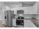 Modern kitchen featuring stainless steel appliances and granite countertops at 6103 Fairway Dr, Ridge Manor, FL 33523