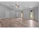Spacious living room with wood-look flooring, vaulted ceilings, and natural light from multiple windows at 6103 Fairway Dr, Ridge Manor, FL 33523