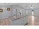 Open living space featuring wood-look floors, high ceilings, and a kitchen island at 6103 Fairway Dr, Ridge Manor, FL 33523