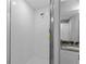 Bathroom featuring white tiled shower with glass door and chrome shower head at 6103 Fairway Dr, Ridge Manor, FL 33523