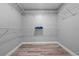 Spacious walk-in closet with wooden floors and white wire shelving for optimal storage at 6103 Fairway Dr, Ridge Manor, FL 33523