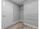 Bright walk-in closet featuring wood-look floors, white trim and wire shelving at 6103 Fairway Dr, Ridge Manor, FL 33523