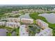 Aerial view of waterfront condos surrounded by a tranquil lake with lush trees and landscaping at 6450 Shoreline Dr Dr # 9202, St Petersburg, FL 33708