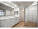 Bathroom featuring double sinks, quartz countertops, and mirrored closet doors for storage at 6450 Shoreline Dr Dr # 9202, St Petersburg, FL 33708