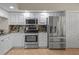 White kitchen with stainless steel appliances and marble backsplash at 6450 Shoreline Dr Dr # 9202, St Petersburg, FL 33708