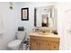 Tiled bathroom with a vanity, toilet, decorative mirror, and a framed picture at 11000 Gulf Blvd # 1002, Treasure Island, FL 33706