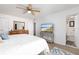 Bright bedroom with a ceiling fan, wood floors, a dresser, and a bathroom in the background at 11000 Gulf Blvd # 1002, Treasure Island, FL 33706