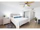 This bright bedroom features a ceiling fan, wood-look flooring, and an ensuite bathroom at 11000 Gulf Blvd # 1002, Treasure Island, FL 33706