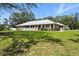 A brick home with a well-manicured lawn and white picket fence, nestled amongst mature trees at 11301 Donneymoor Dr, Riverview, FL 33569