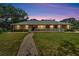 Exterior view of a charming brick home at twilight with beautiful landscaping and pathway at 11301 Donneymoor Dr, Riverview, FL 33569